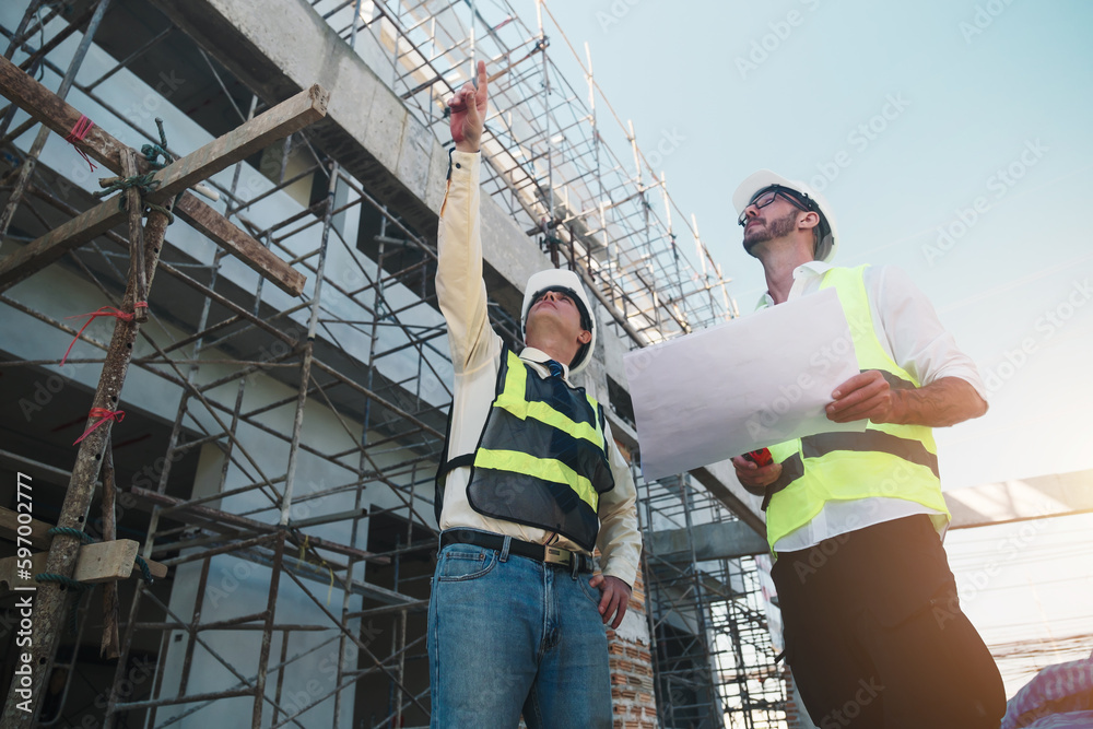 Contractor and engineer architect working together planning using blueprint design structure construction industry, building house innovation and teamwork discussing, two male caucasian collaborating.