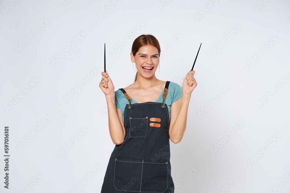 Young woman wearing kitchen apron holding chopsticks isolated on white background. Young woman wearing kitchen apron holding chopsticks isolated on white background.