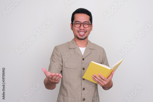 Indonesian school teacher smiling happy while holding a book photo