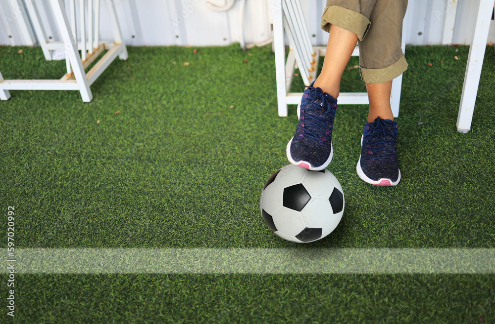 Obraz premium woman foot step on football beside the grass field represent to she is a team manager.