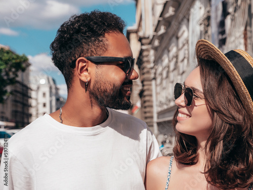 Smiling beautiful woman and her handsome boyfriend. Woman in casual summer clothes. Happy cheerful family. Female having fun. Sexy couple posing in the street at sunny day. In hat and sunglasses