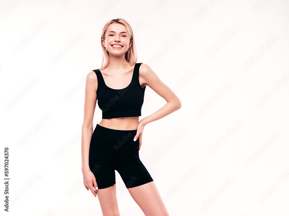 Young beautiful smiling blond female in black cycling shorts clothes. Sexy carefree woman posing on white background in studio. Positive model having fun indoors. Cheerful and happy Young beautiful smiling blond female in black cycling shorts clothes. Sexy carefree woman posing on white background in studio. Positive model having fun indoors. Cheerful and happy