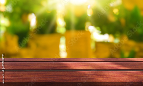 Wooden table top with natural green blurred background or various leaves, fresh bright sunlight, product empty concept.