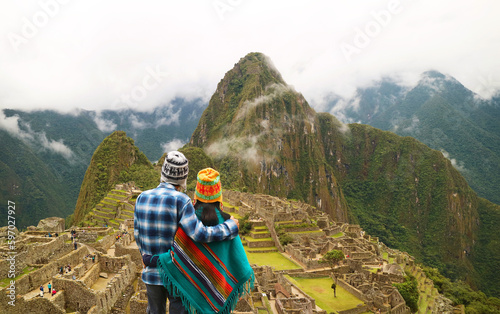 Couple being impressed with the incredible view of Machu Picchu ancient Inca citadel, UNESCO world heritage site in Cusco Region, Peru, South America