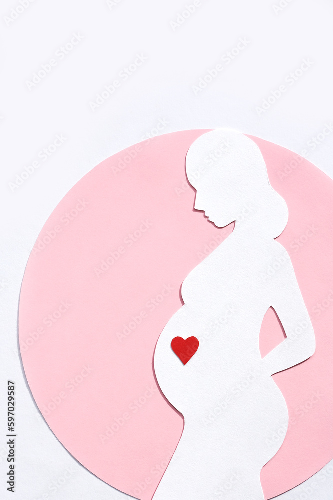 Paper silhouette of a pregnant woman in a pink circle on a white background. Vertical image, flat lay, copy space. Paper silhouette of a pregnant woman in a pink circle on a white background. Vertical image, flat lay, copy space.