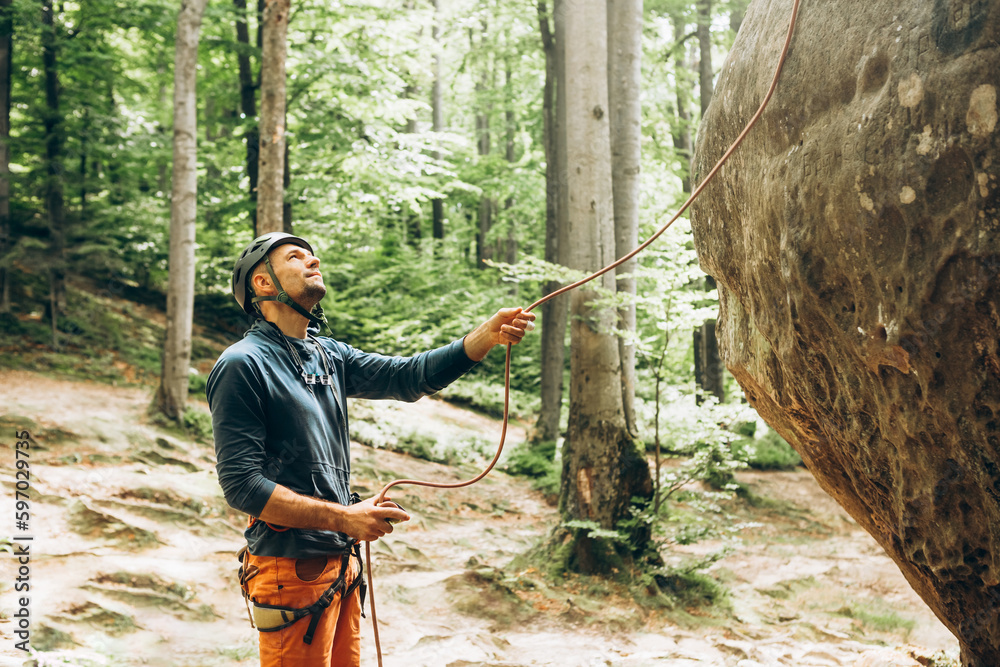 Ταπετσαρία man standing near the rock and belaying the climber,belay device and rope in cli