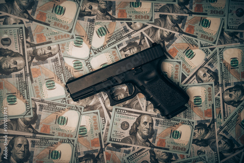 A police officer's pistol sits on a pile of dollars, bribery police, corrupt police.