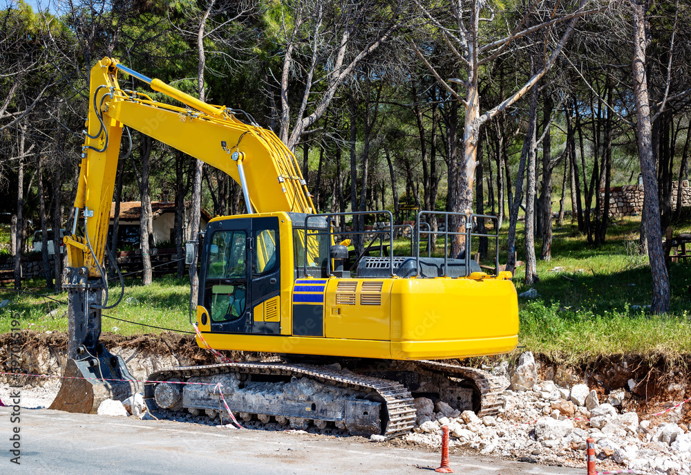 excavator working on the construction of a road in the forest