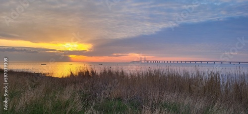 Sunset by the sea overlooking a field and the Öresund bridge in Malmö, Sweden