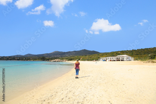 A woman is walking along the White Beach (Spiaggia Bianca) in Golfo Aranci - Sardinia