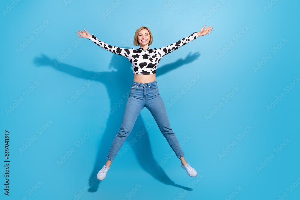 Full body size cadre of young beautiful girl blonde bob hair wear cow skin shirt denim jeans jump star isolated on blue color background
