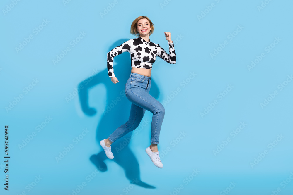 Full length profile portrait of energetic excited person jumping rush isolated on blue color background