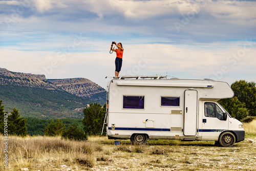 Fotobehang Woman traveling with caravan, taking photo from rv roof