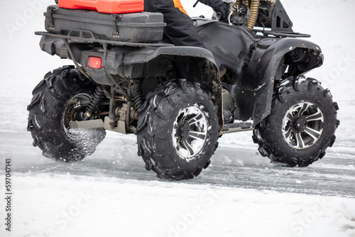 Quad bike rides on white snow in winter. Sport