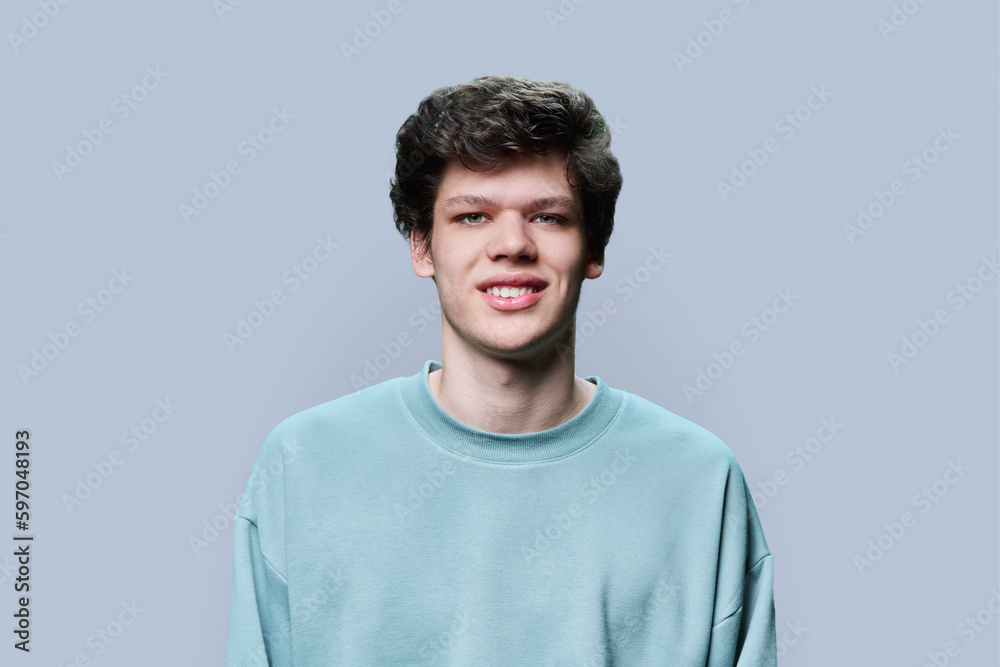 Headshot portrait of young male in casual sweatshirt, on gray background Headshot portrait of young male in casual sweatshirt, on gray background