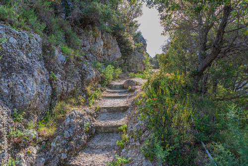 A hiking trail in the mountains of the island of Corfu in Greece. A beautiful stairway with a jubilee of vegetation.