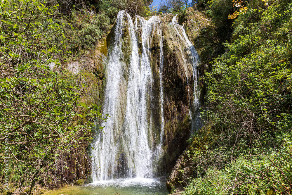 A beautiful waterfall in the mountains on the island of Corfu in Greece. A tourist spot for nature lovers. 