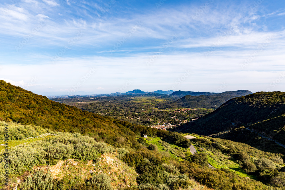 A beautiful landscape of the island of Corfu in the Ionian Sea in Greece. Mountains with plenty of green vegetation. Thick clouds over the island. 