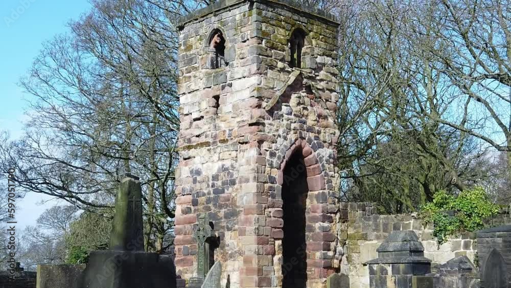 Historic Windleshaw Chantry stonework tower exterior slow motion around cemetery ruins against blue sky