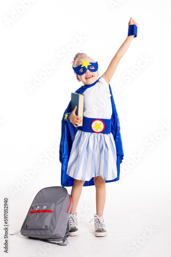 School girl wearing superhero mask and suit delighted kid posing for ready to school concept.