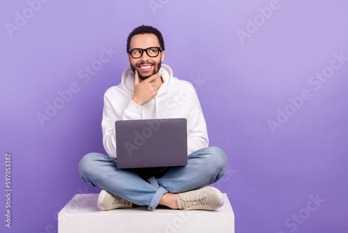 Full body size cadre of deciding man young touch beard use netbook look mockup planning his weekend isolated on purple color background