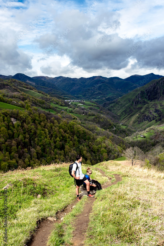 Young couple hiking in the mountains of the French Basque Country with their dog
