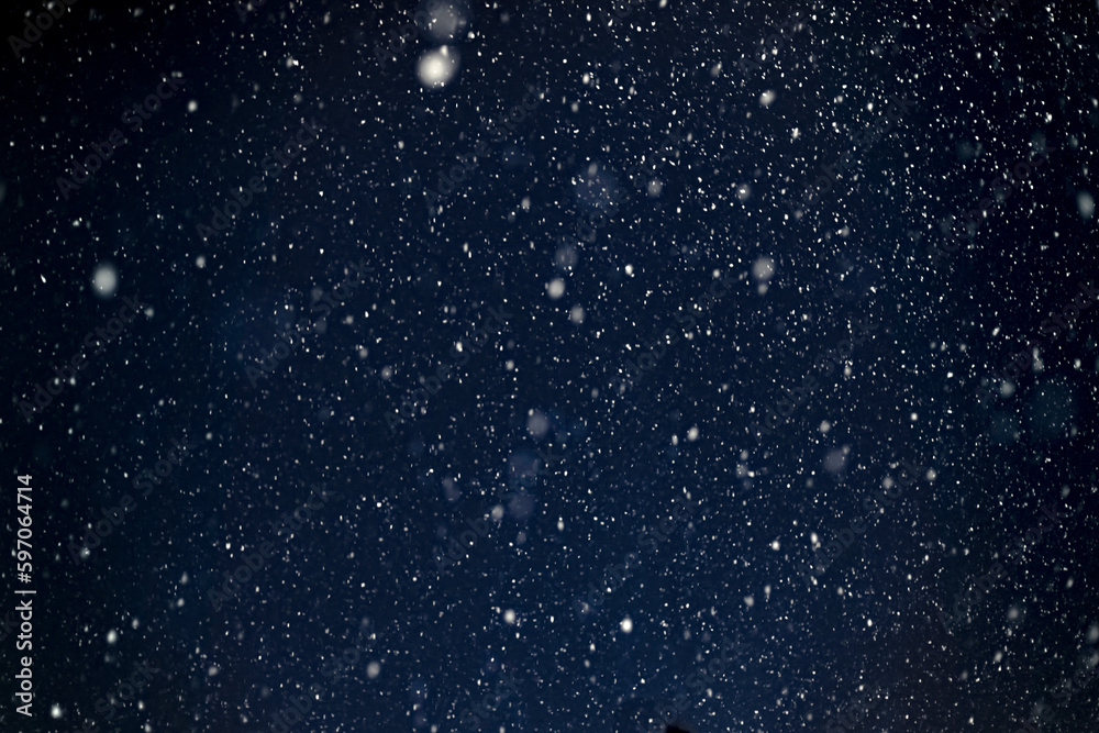 Fototapeta premium blizzard natural blurred background, flying snow shot against the night sky
