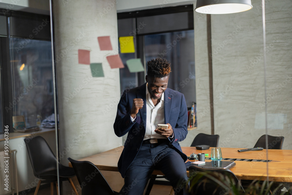© JustLife - Portrait of successful businessman in office. Handsome businessman using phone..