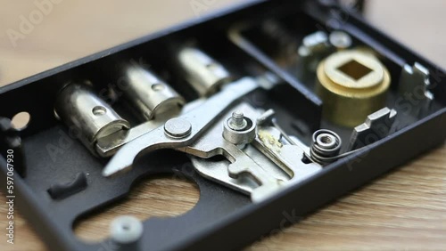 Wallpaper Mural A man puts a disassembled door lock on a wooden table. macro photography. Torontodigital.ca