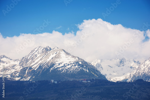 slovakia countryside in spring. snowcapped peaks beneath huge white clouds. nature background in gorgeous light © Pellinni