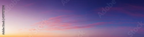 panorama of heavens at dawn. clouds in red and orange colors of a rising sun on a blue sky