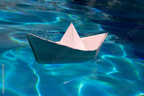 Paper ship sail. Paper boat on the sea water background. Dreaming traveling. © Volodymyr