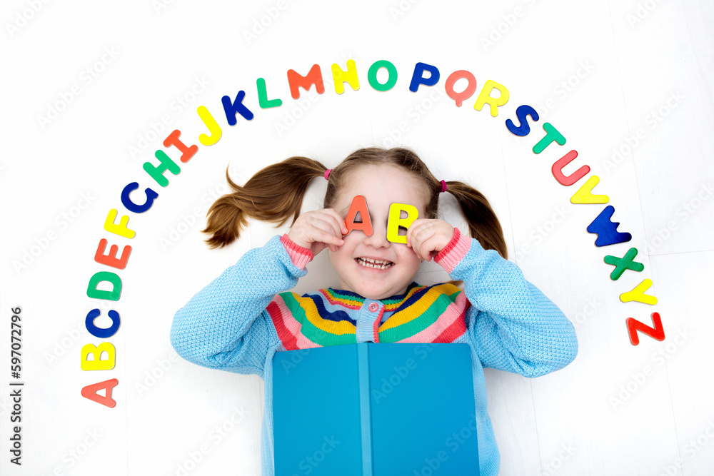 Child learning letters of alphabet and reading Stock Photo | Adobe Stock