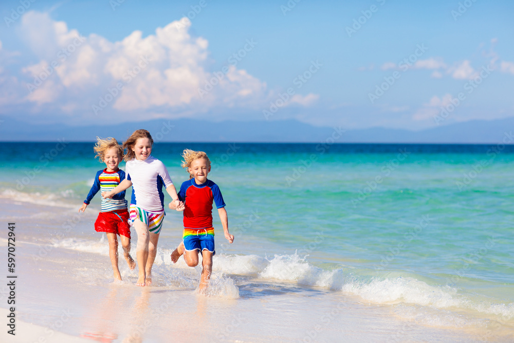 Kids playing on beach. Children play at sea.