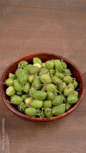 Fresh Green chickpeas on a branch, and in the pod, isolated on wooden background.