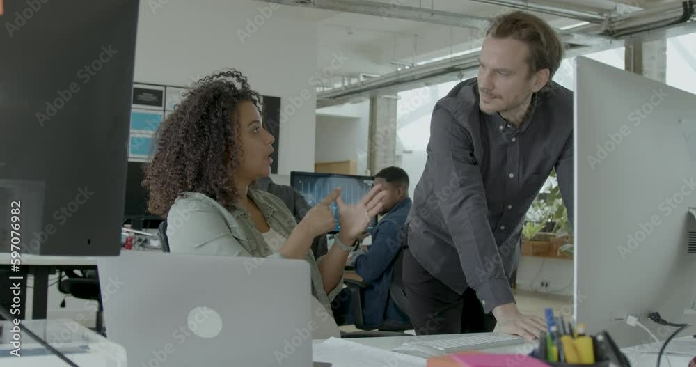 Two Business People Meeting at a Desktop Computer in an Office