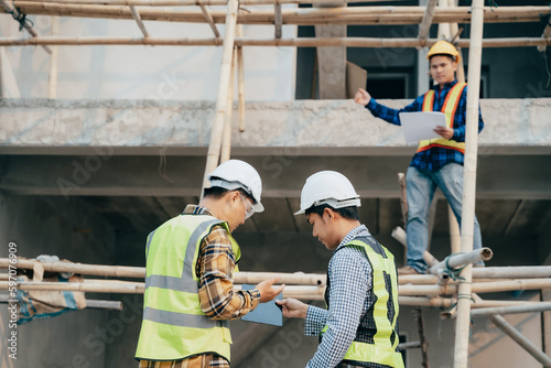 civil engineer and worker discussing issues at the construction site in the morning.