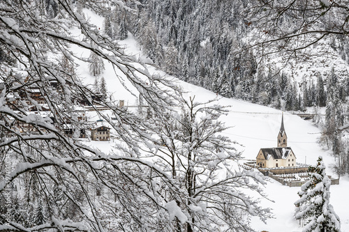 Snowfall in Sauris. Among the woods and historic houses. photo