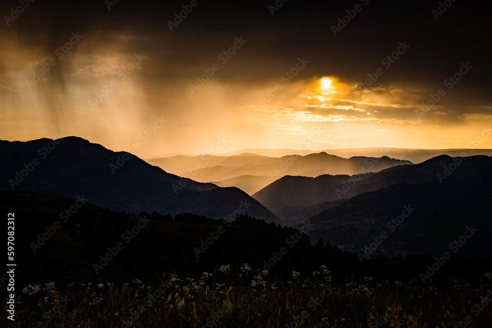 Obraz premium banner of mountain peaks in beautiful stormy sunset light