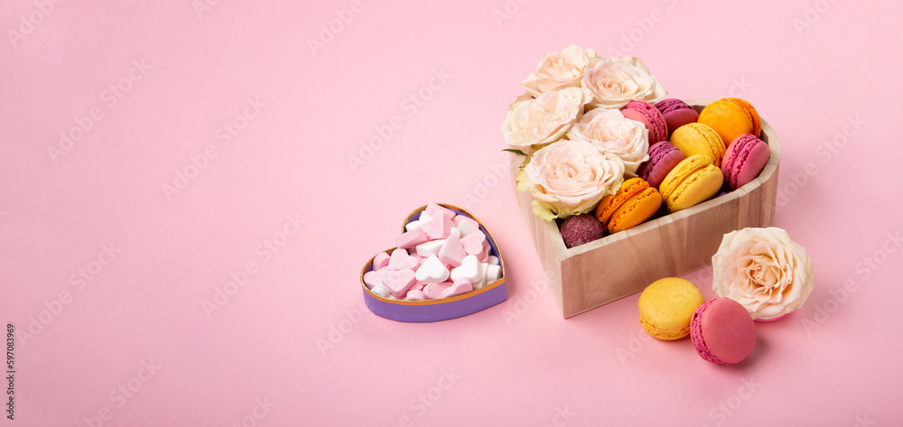 Obraz premium Cookies Macaroons in Gift Box, Rose Flowers and Candies on Pink Background. Holiday Presents Concept