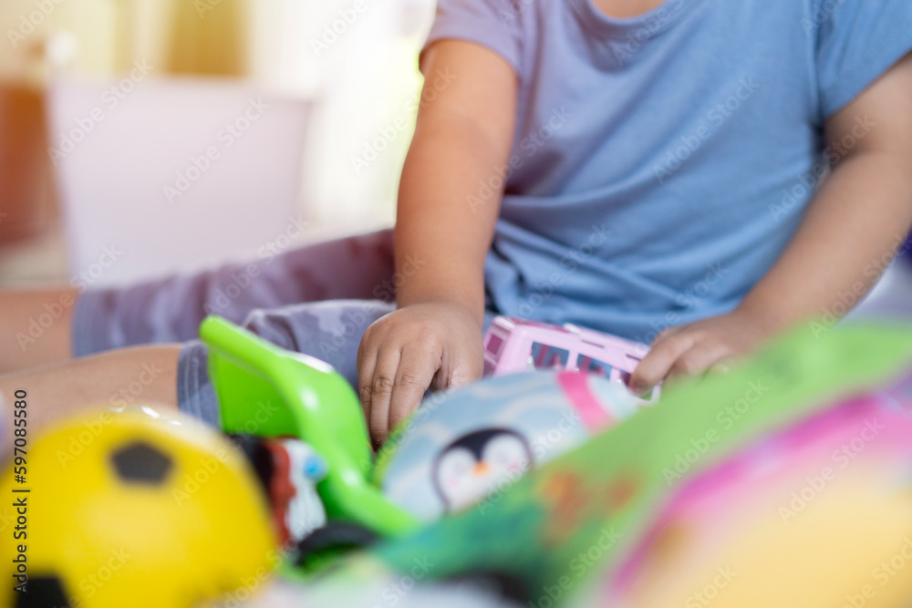 Little child playing with lots of colorful plastic toys indoor. Toys for preschool and kindergarten concept. Little child playing with lots of colorful plastic toys indoor. Toys for preschool and kindergarten concept.