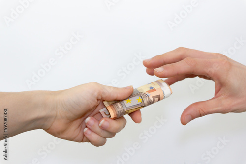Financial transaction: Hand giving and receiving rolled 50 euro bills
