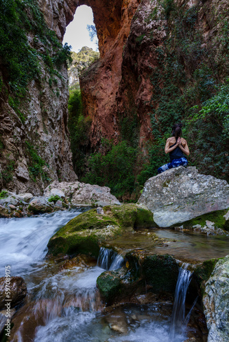 woman practicing yoga by the river, God's Bridge, Akchour, Talassemtane Nature Park, Rif region, morocco, africa