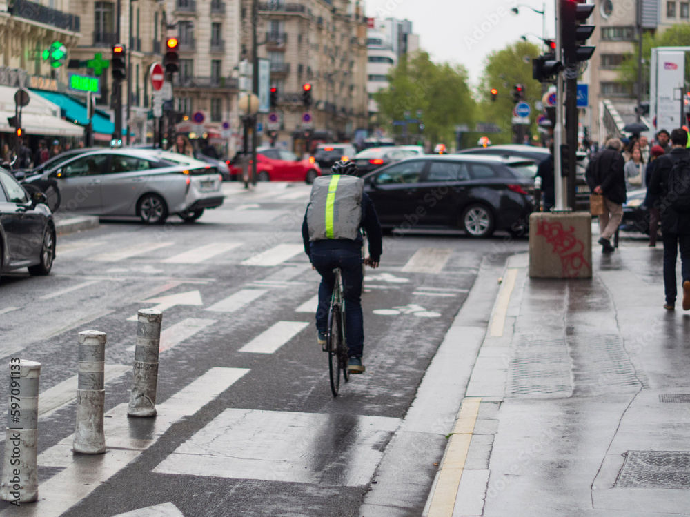Cycliste parisien avec un sac à dos qui roule vite