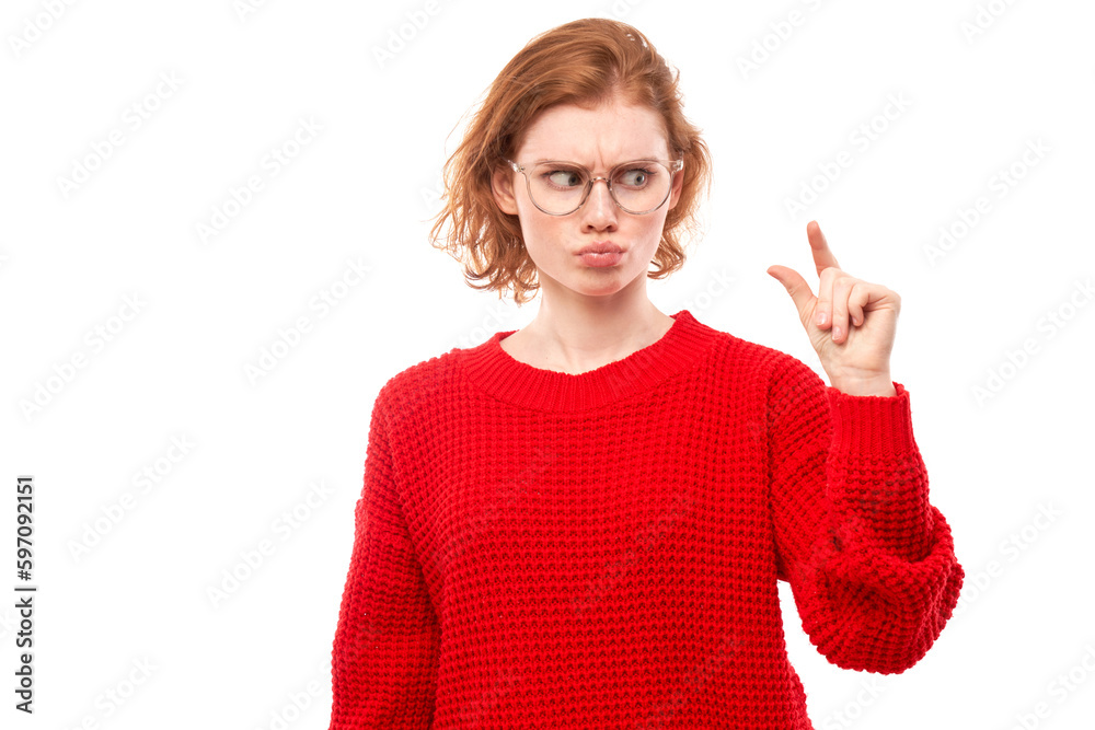 Portrait funny redhead young woman showing small size with fingers isolated on white studio background Portrait funny redhead young woman showing small size with fingers isolated on white studio background