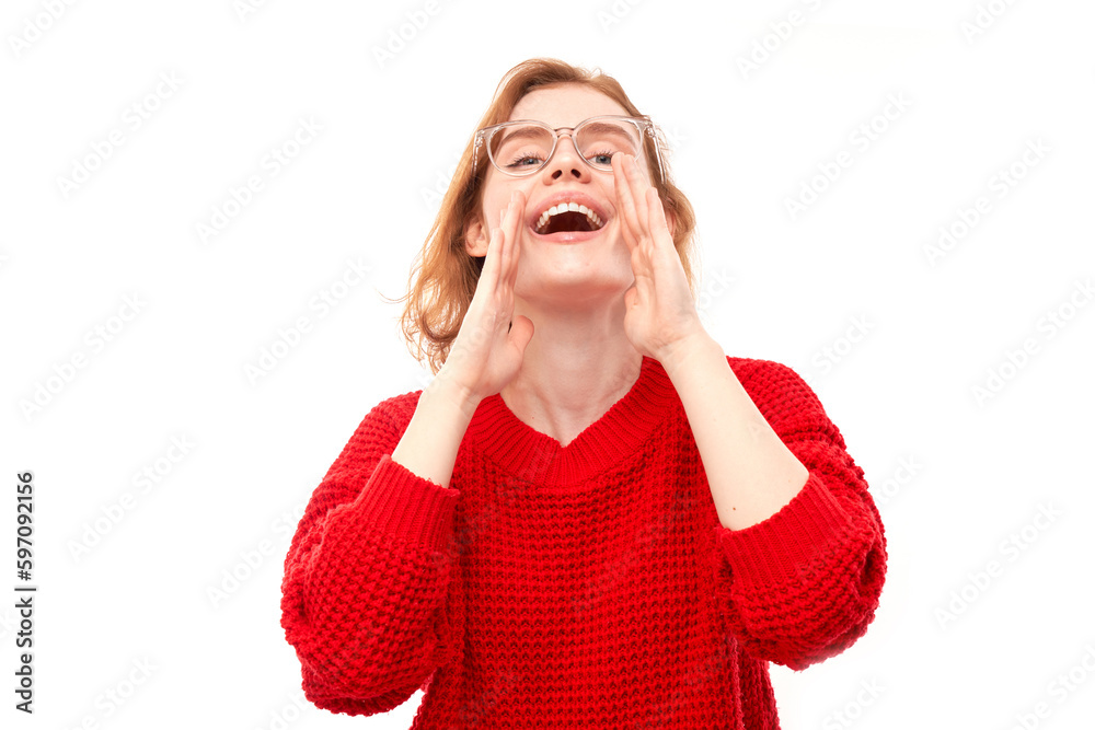 Portrait of redhead young woman screaming into her palms on white studio background. Important information, news concept Portrait of redhead young woman screaming into her palms on white studio background. Important information, news concept