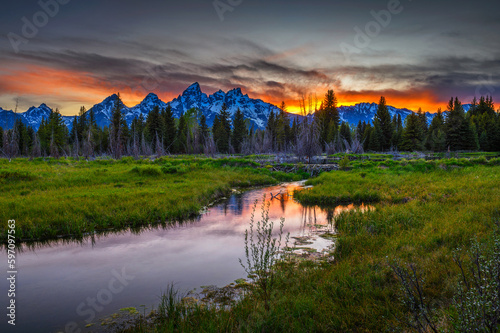 Sunset over Schwabacher Landing with Teton Mountain Range reflected in the waters of Snake River in Wyoming, USA.