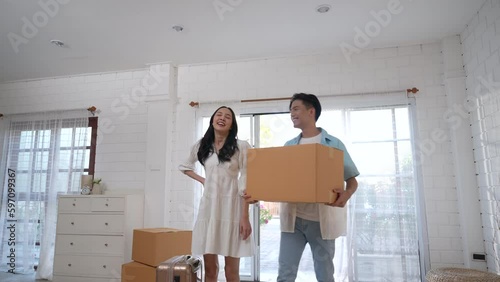 Happy Asian couple moving into their new home.