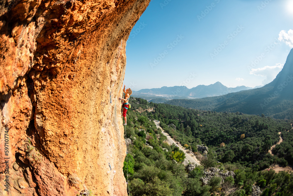 Girl climbs on the rock, rock climbing in Turkey, the sports girl is engaged in rock climbing.