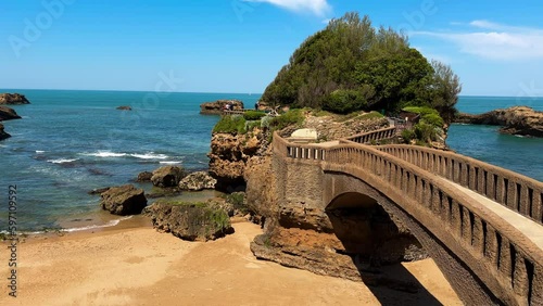Stone bridge to the Rocher du Basta, the scenic rock and major landmark in the coast of Biarritz, France. High quality 4k footage